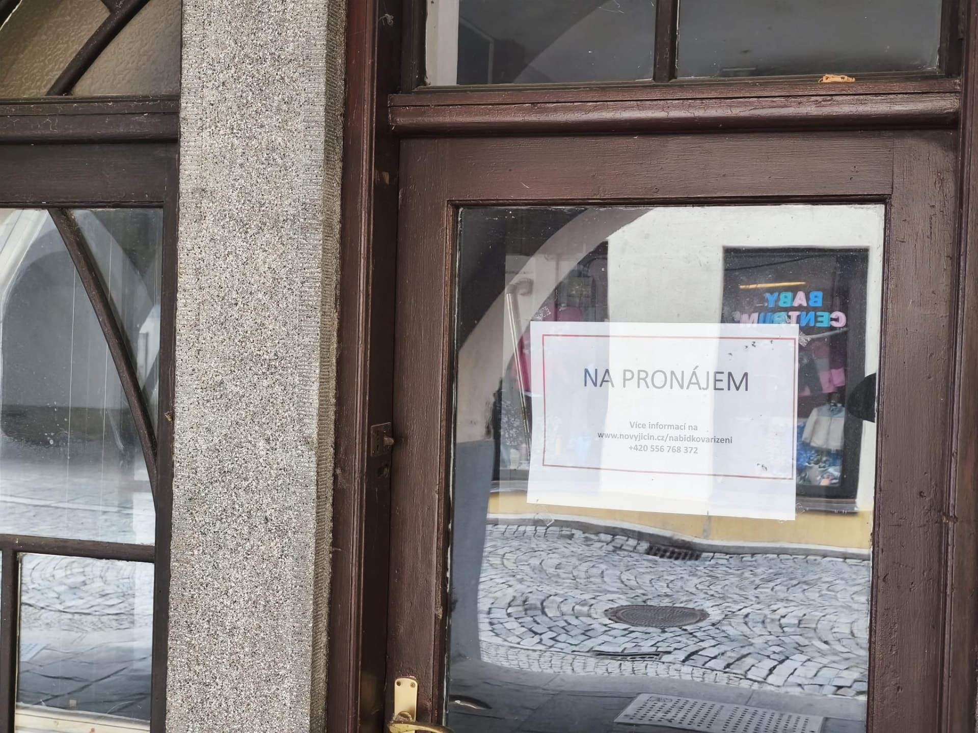 Zavřený vchod podloubí s cedulí Na pronájem