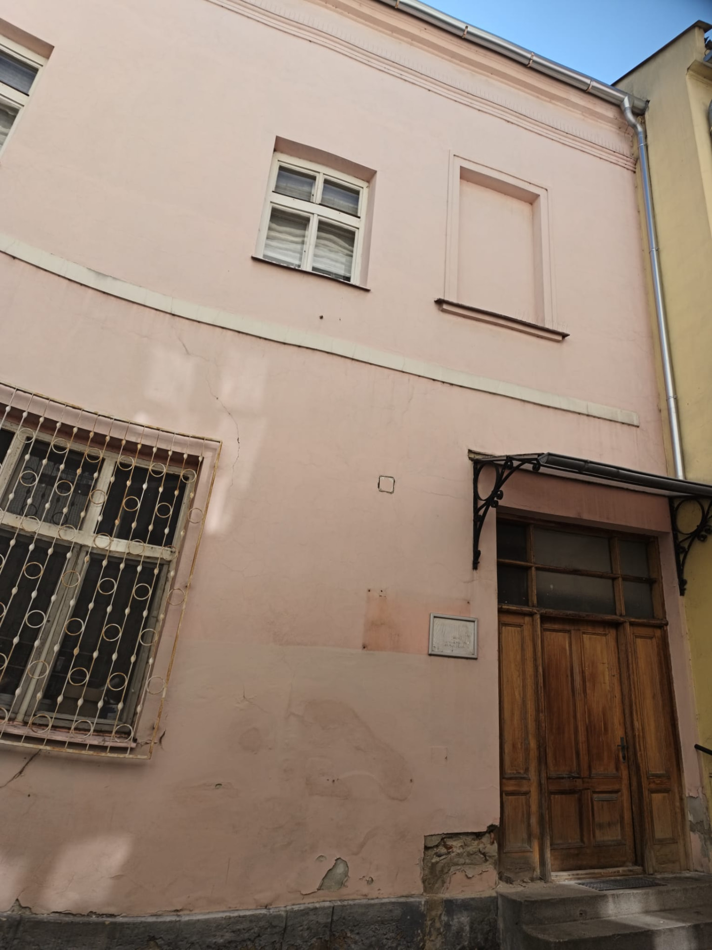 Dům na Jungmannově ulici – detail fasády s poškozenou omítkou