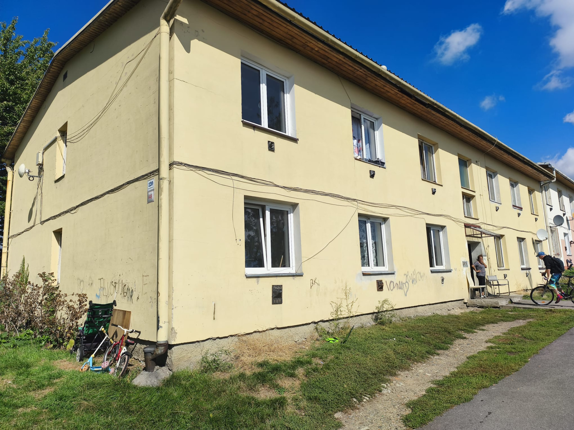 Holobyt na Suvorovově ulici – dům s dětmi u vchodu